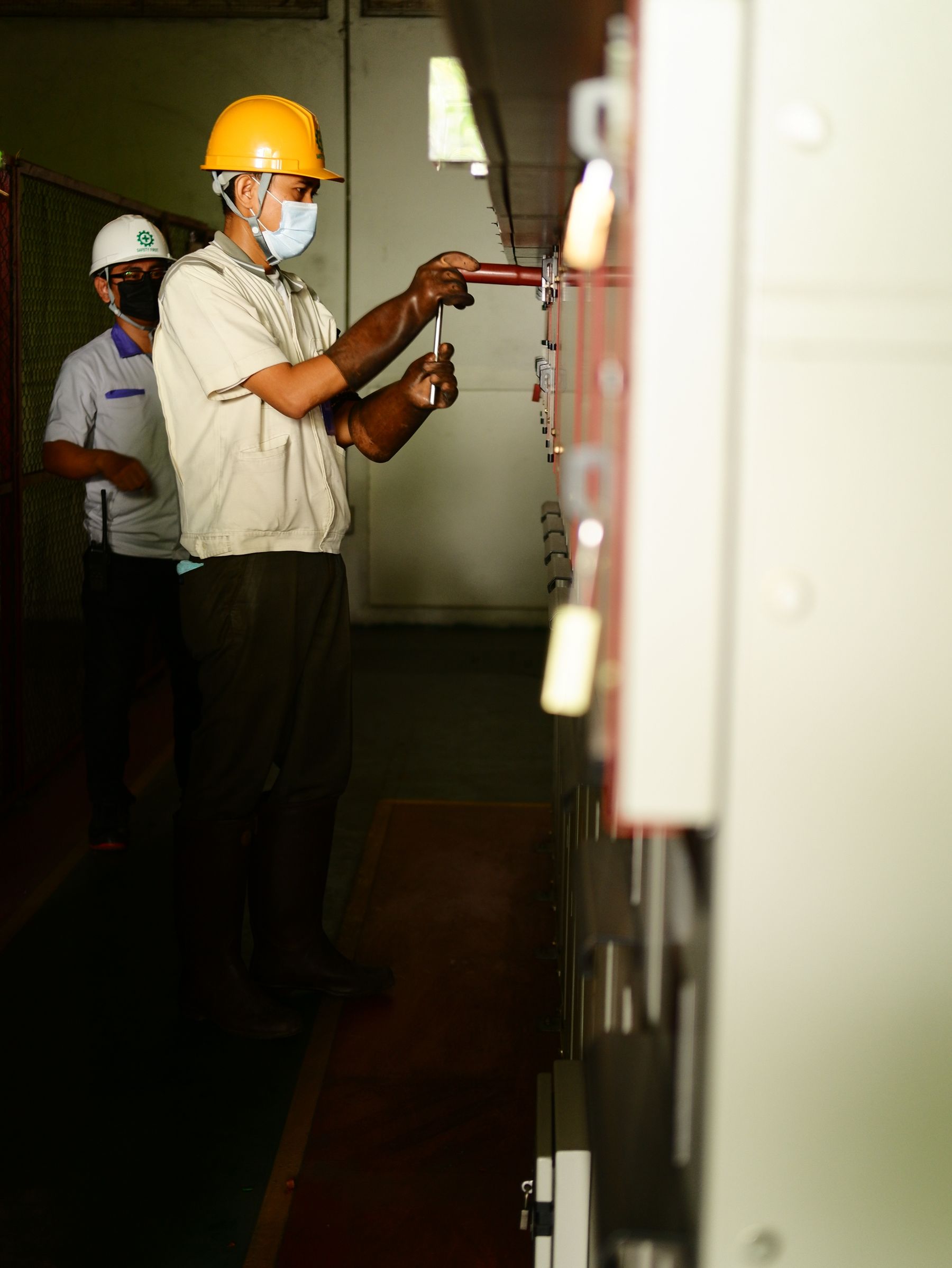 Electrical workers attending to equipment — illustrative stock photography